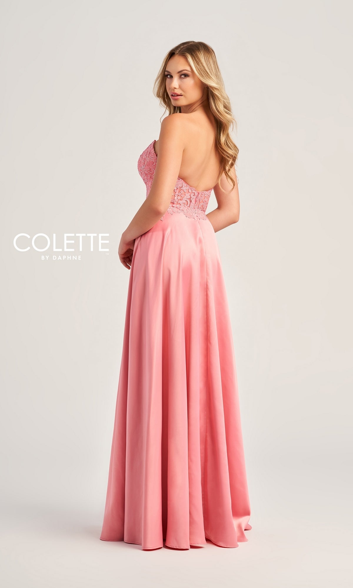 A woman poses from the back in a strapless pink Colette Strapless Long Designer Prom Dress CL5142 with a fitted bodice and flowing skirt, against a plain background. The text